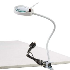 Lampe loupe avec une pince fixé sur le bureau blanc et le câble d'alimentation sur le bureau
