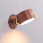 lampe murale de chevet marron en bois est accrochée à un mur blanc et est allumée