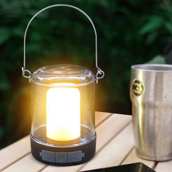 Lampe camping façon lanterne posée sur une table.
