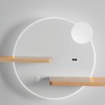 lampe murale design ronde blanche avec de petites étagères intégrées , installée sur un mur beige