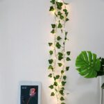 Guirlande lumineuse LED style feuilles de vignes pour décoration intérieure installée le long d'un mur blanc