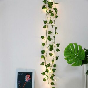 Guirlande lumineuse LED style feuilles de vignes pour décoration intérieure installée le long d'un mur blanc