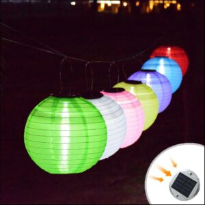 Lampe lanterne en forme de globe coloré à énergie solaire présentée en guirlandes, de plusieurs couleurs différentes, dans la nuit