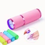 Lampe torche Miniature UV LED sèche-ongles présenté sur fond blanc et avec une démonstration sur des ongles