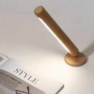 Lampe murale rotative à LED en bois éclairant un magazine
