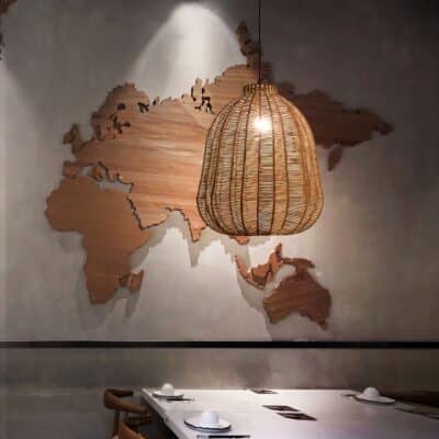 Lampe plafond en rotin forme cloche présentée au-dessus d'une table