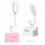 Deux lampes de bureau avec réservoir dans le socle, tige flexible. Une rose allumée à gauche et une blanche à droite, sur fond blanc.