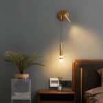Lampe murale rotative au style moderne dorée allumée dans une chambre