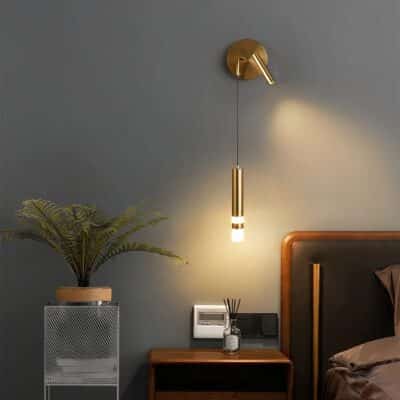 Lampe murale rotative au style moderne dorée allumée dans une chambre