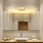 Lampe salle de bain dorée chic et raffinée allumée dans une salle de bain au-dessus d'un miroir