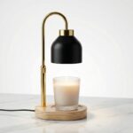 Notre lampe chauffe bougie électrique, sécurisée et réglable au style scandinave avec support en bois, corps en métal doré et l'abat-jour noir.