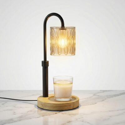 La lampe chauffe bougie moderne et élégante noire présente une base en bois clair, sur une table en marbre clair.