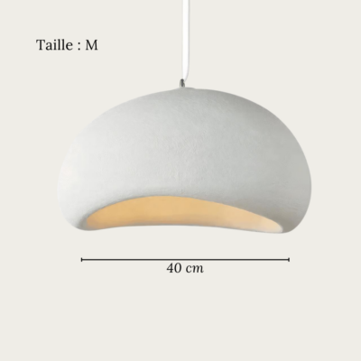 Une suspension Wabi Sabi en plâtre effet pierre minimaliste blanche, suspendue au plafond et diffusant une lumière douce dans une pièce claire.