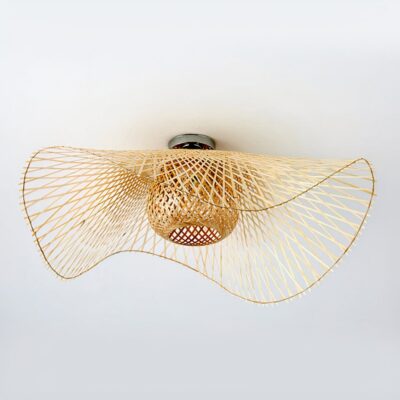 Un lustre en rotin bohème ondulé pour chambre adulte, en forme de grande vague légère, suspendu au plafond sur fond blanc.