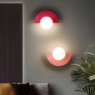 Lampe murale demi-cercle rouge framboise et rose corail allumées dans un salon
